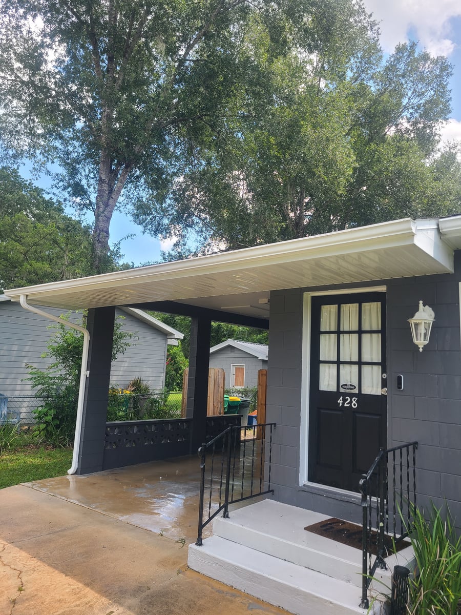 Exterior house washing and gutter cleaning with debris removal