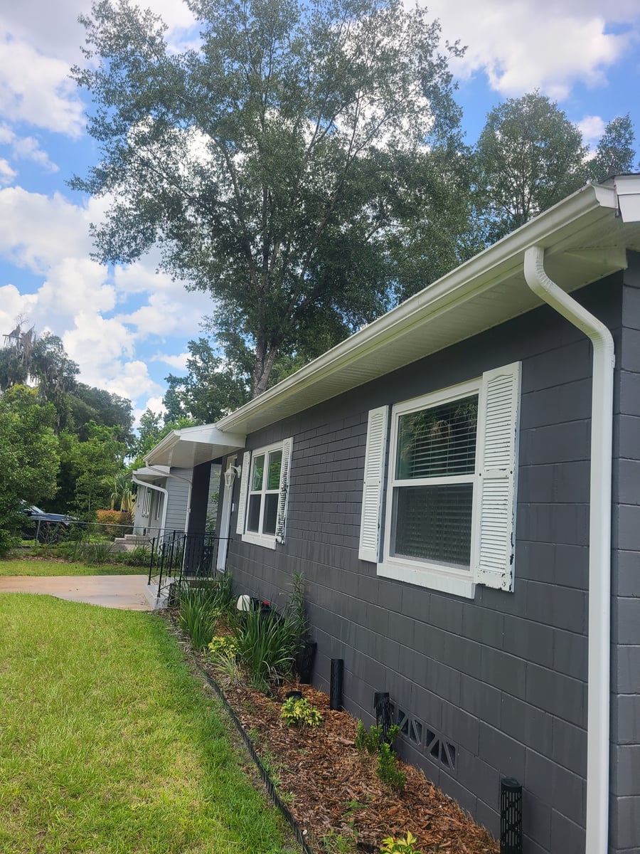 Exterior house washing and gutter cleaning with debris removal