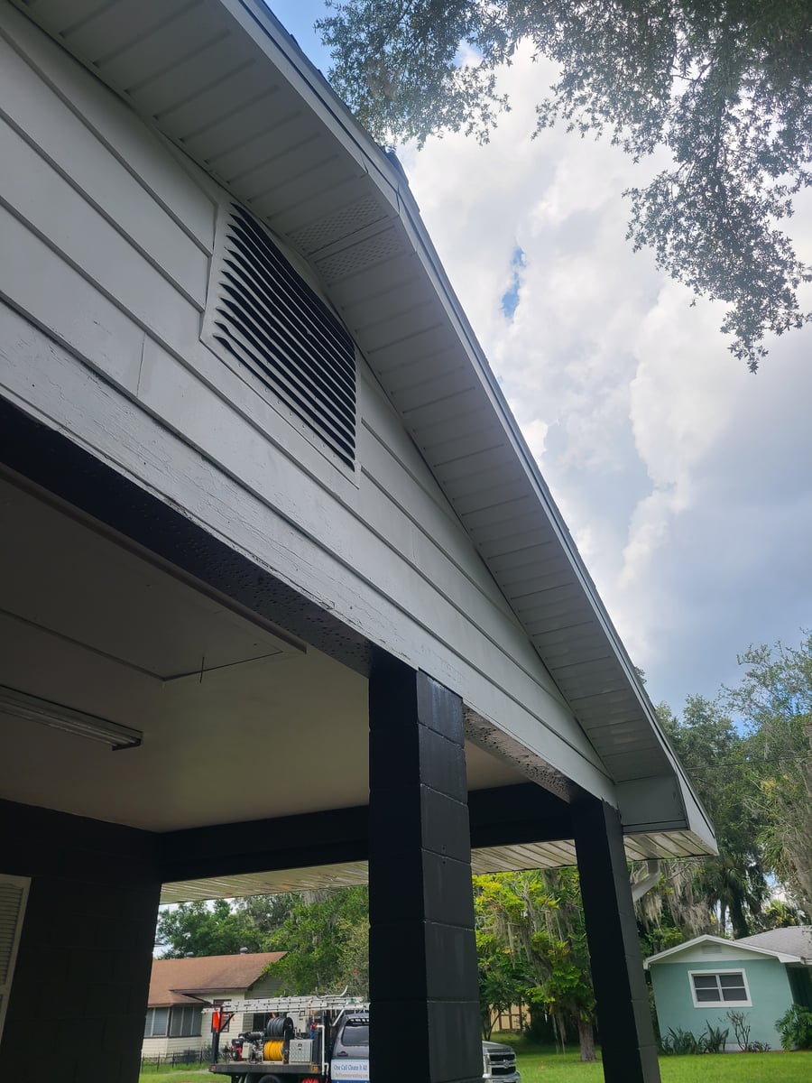 Exterior house washing and gutter cleaning with debris removal