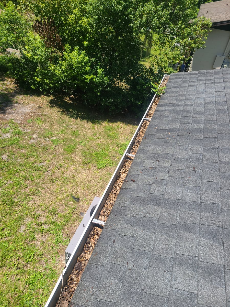 Exterior house washing and gutter cleaning with debris removal